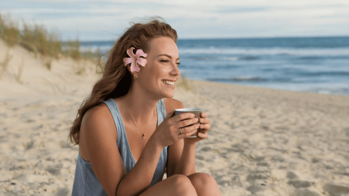 Femme profitant d'un moment de détente au bord de la mer pour retrouver un équilibre face à la surcharge mentale.