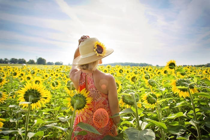 Femme dans un champ de tournesols symbolisant le changement et la confiance en soi