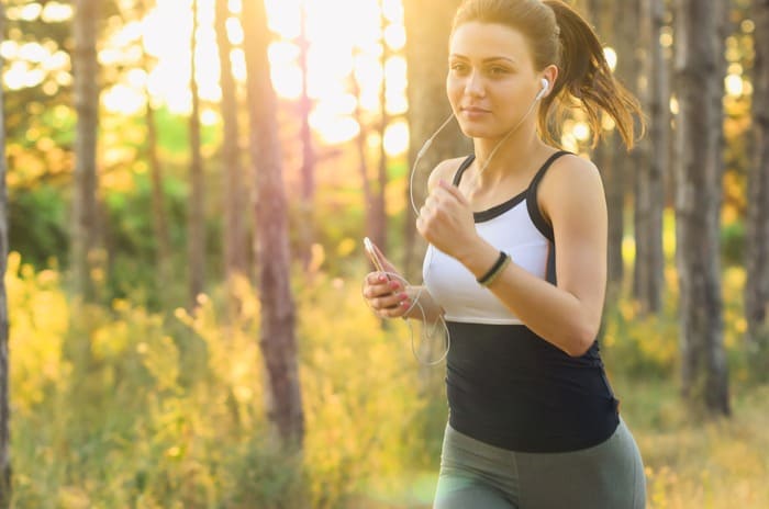 Femme en mouvement dans la nature pratiquant une activité favorisant le bien-être