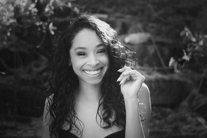 eune femme souriante illustrant le bien-être, la sérénité et les bienfaits de la sophrologie.