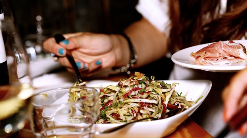 Femme se servant une salade composée lors d'un repas partagé